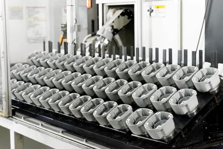 二次CNC加工工程に投入されるアルミ合金ダイカスト筐体のインライン自動ローディングシステム