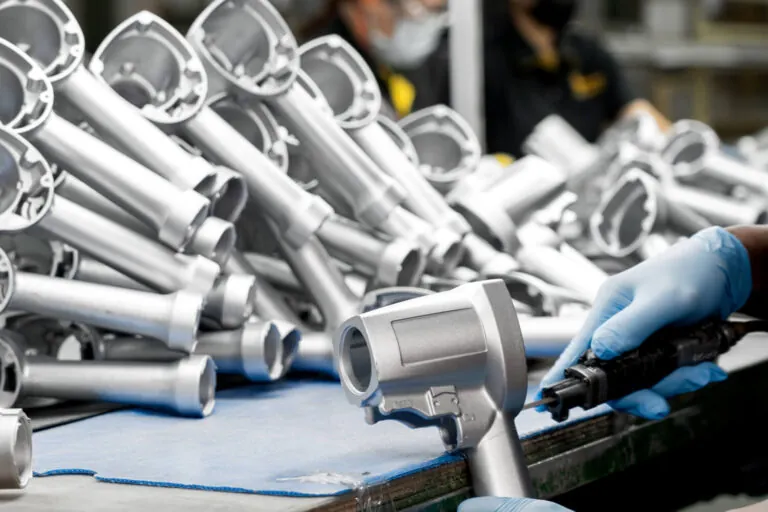 コーティング前のアルミ空圧工具ハンドルに対し、熟練技術者が手作業でバリ取りおよび精密表面処理を実施