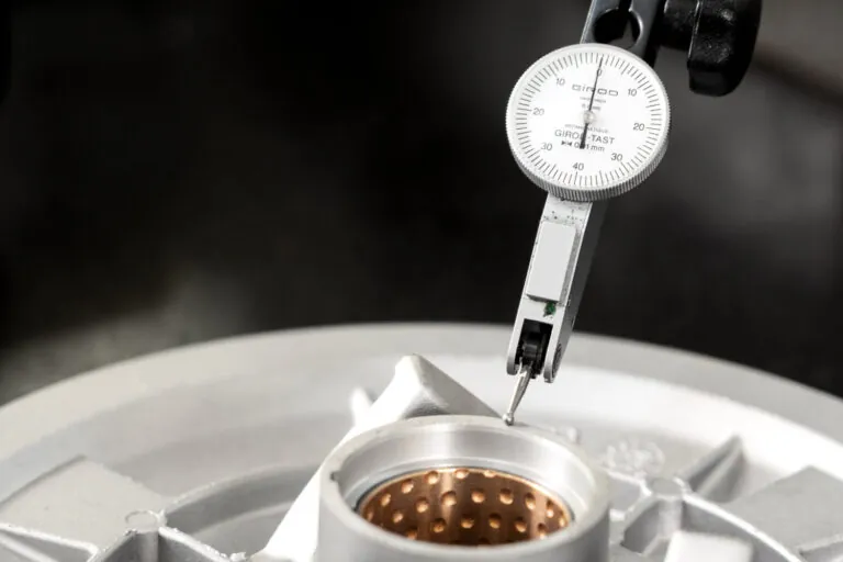 ±0.01mmの厳格な公差を確保するため、アルミ合金ダイカスト部品の重要ボアを測定する高精度ダイヤルゲージ