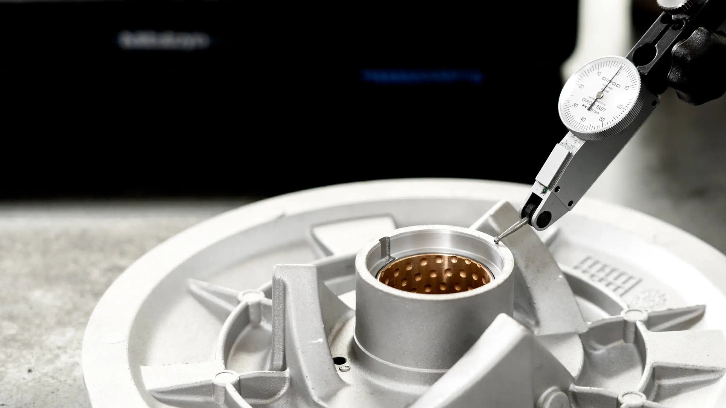 ±0.01mmの厳格な公差を確保するため、アルミ合金ダイカスト部品の重要ボアを測定する高精度ダイヤルゲージ